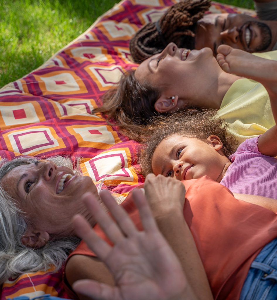 Family laying on picnic blanket